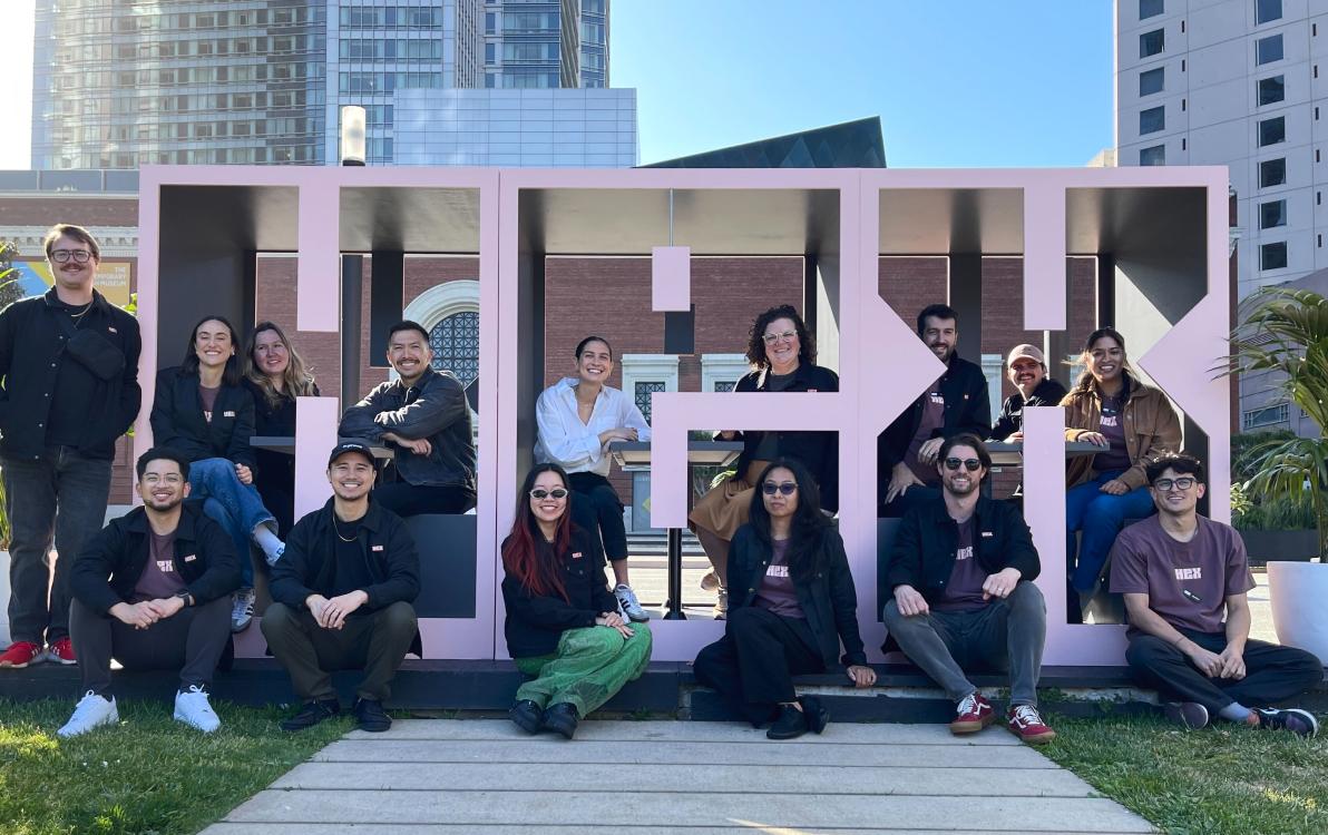 Hex team members posing together in front of large HEX letters at a company event