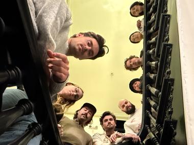 Hex team members looking down through a stairwell, photographed from below